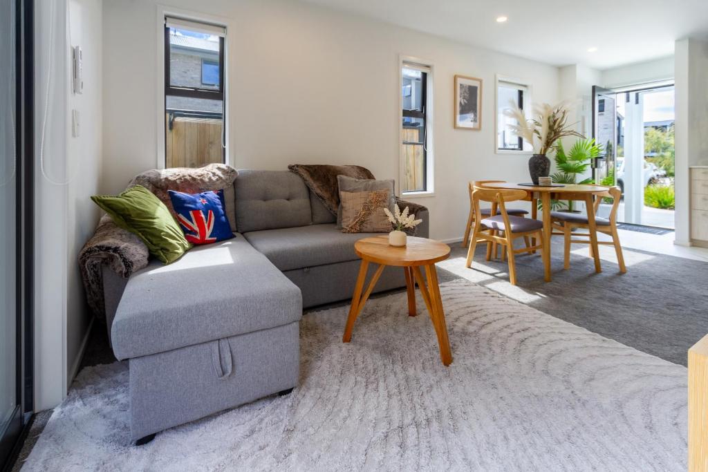 a living room with a couch and a table at Escape at the park: 1 bed 1 bath w/carpark in Christchurch