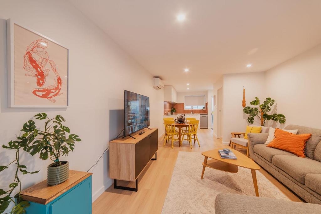 a living room with a couch and a tv at The 2BR Hereford Haven - Relax Recharge Repeat in Christchurch