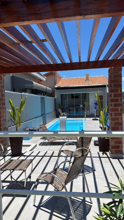 a patio with a table and chairs and a swimming pool at Vaz Lobo Kitnets in Mococa