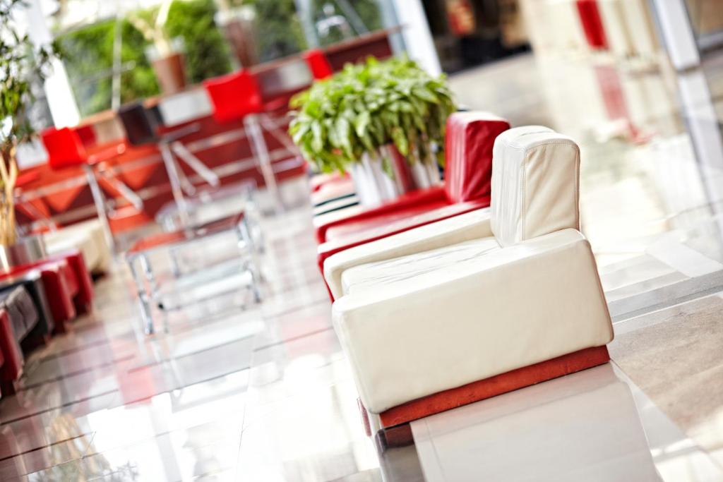 a white chair and red chairs in a room at Hotel Mazurkas in Ożarów Mazowiecki