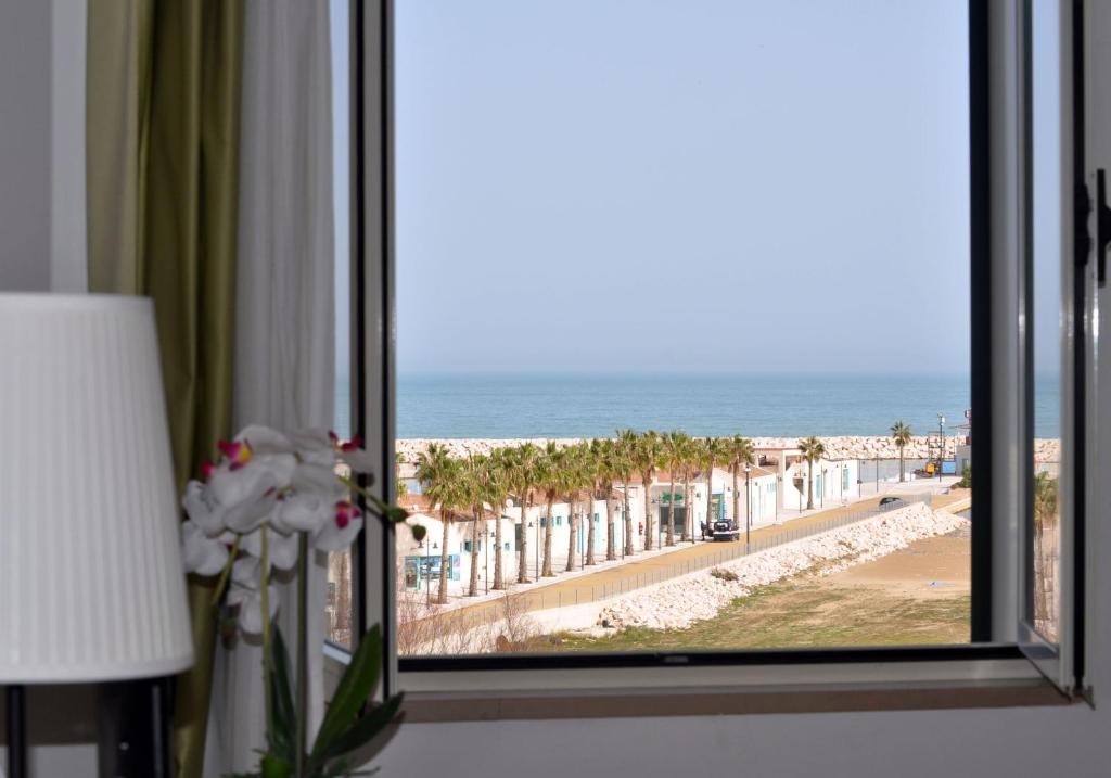 a room with a window with a view of the beach at Hotel Solaria in Rodi Garganico