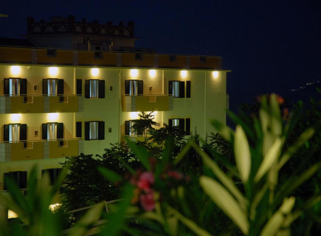 a yellow building with lights on it at night at Hotel Solaria in Rodi Garganico