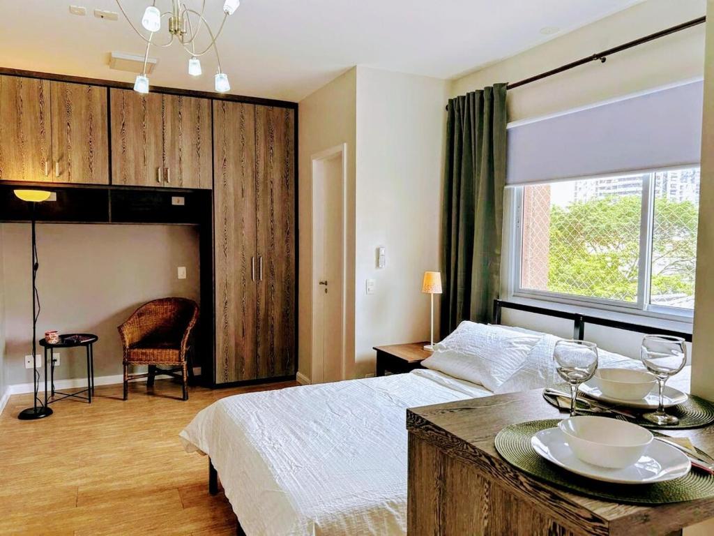 een slaapkamer met een bed en een tafel met borden erop bij Define Pinheiros 34 in Sao Paulo