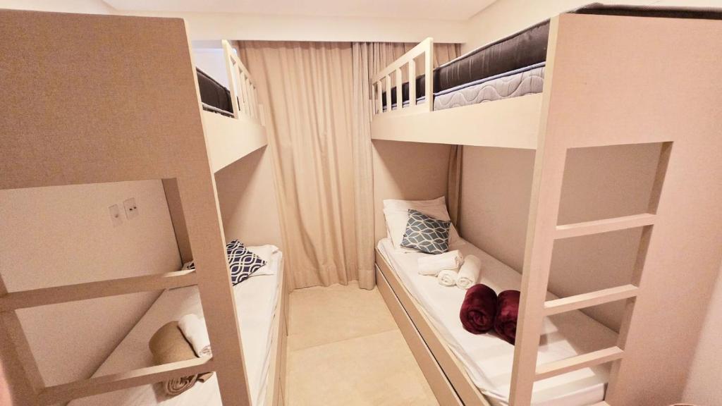 a small room with two bunk beds in it at Flat Muro Alto Ecolife in Porto De Galinhas
