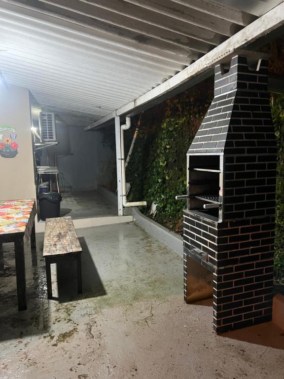 un patio con un horno de ladrillo y una mesa en Casa aconchegante em Ubatuba, en Ubatuba
