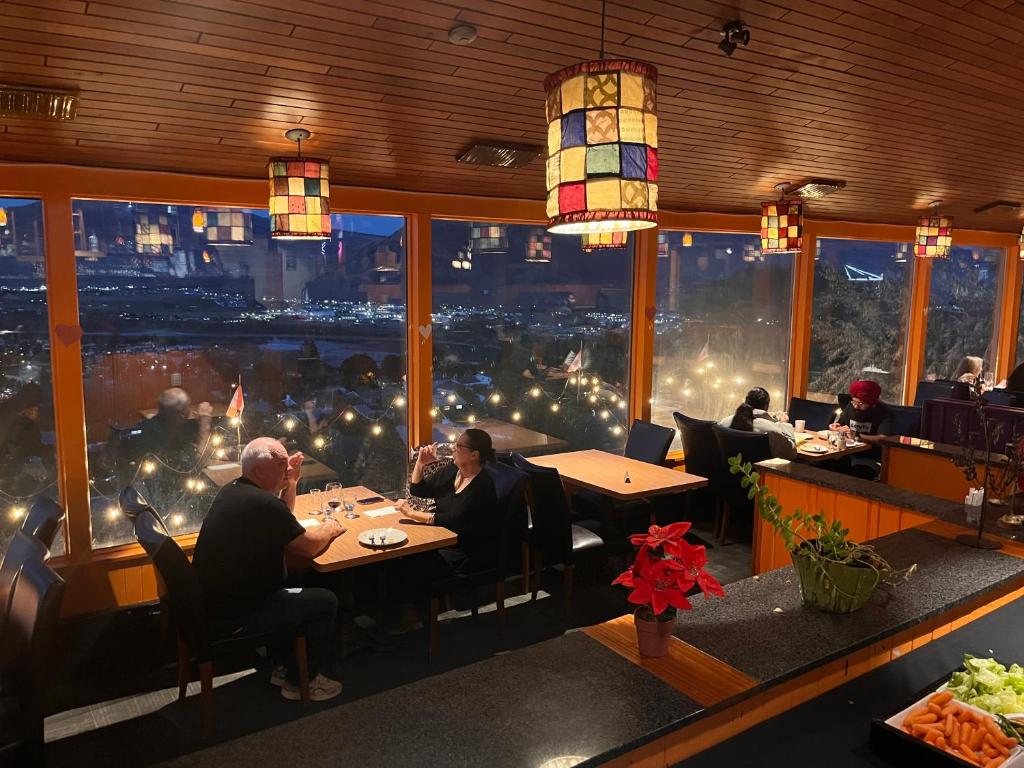 a group of people sitting at tables in a restaurant at The Vista Inn in Kamloops