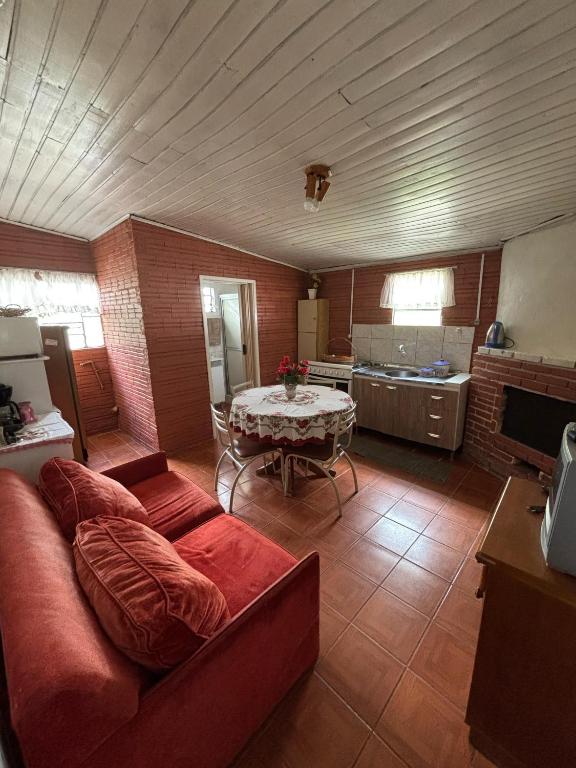 a living room with a red couch and a table at Casa Hospedes in Canela