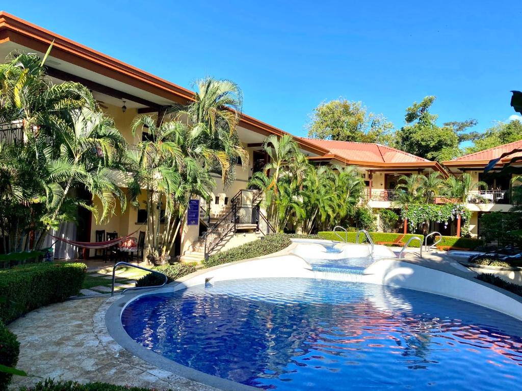 a swimming pool in front of a house at Jaco Hideaway Oasis in Jacó