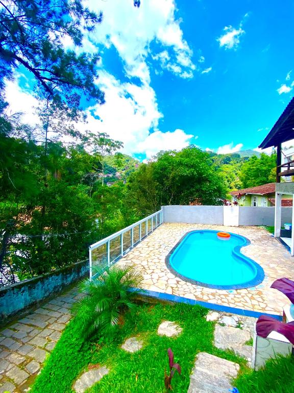 a small swimming pool in a yard with a fence at Casa Monte Verde in Petrópolis