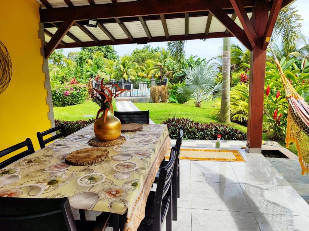 una mesa de comedor con un jarrón encima en Location villa et piscine privé, en Capesterre-Belle-Eau