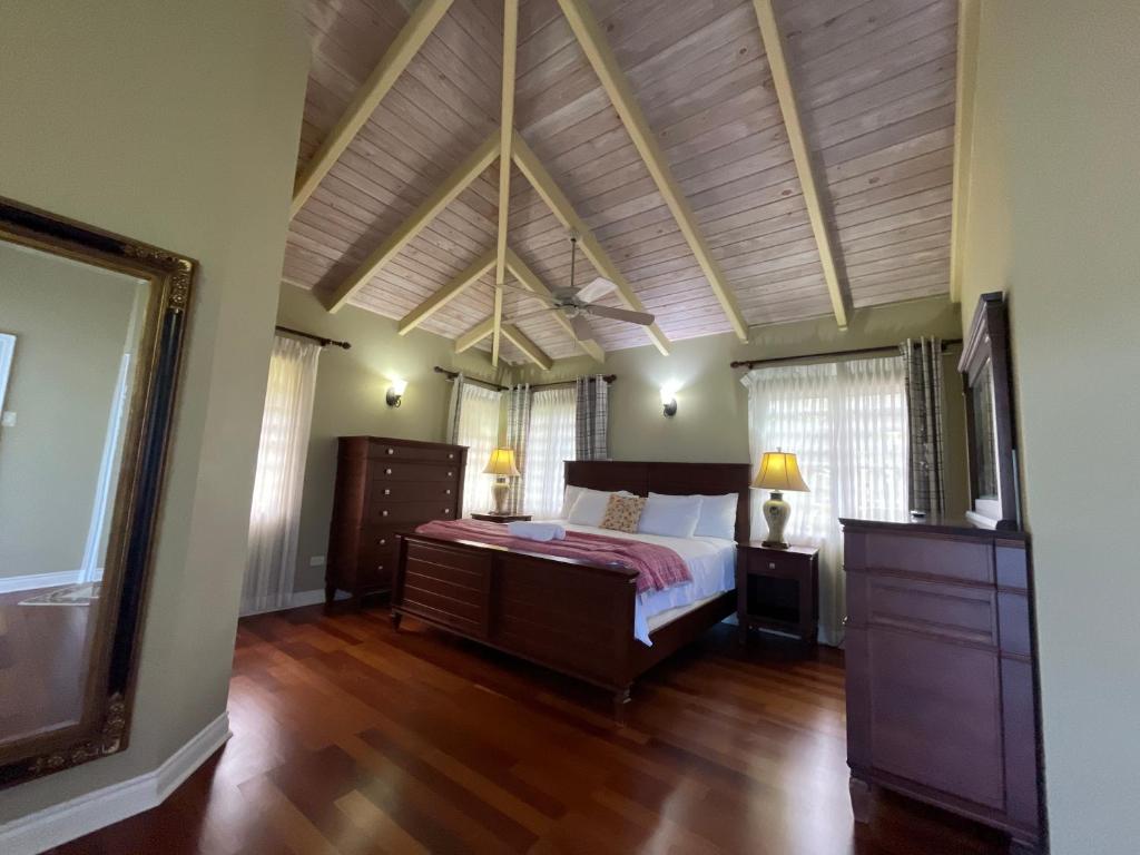 Un dormitorio con una cama y suelo de madera. en Luxury Spacious Villa with Aircon and Pool Table, en Olveston