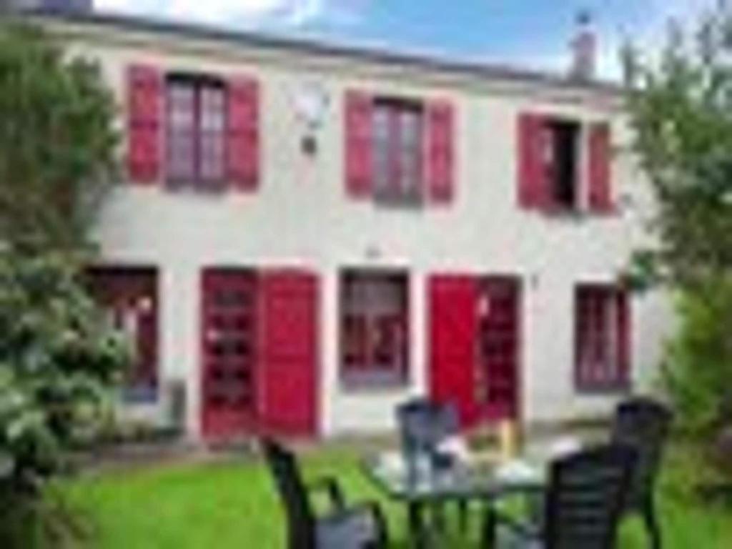 une maison avec des portes rouges et une table devant elle dans l'établissement Holiday Home in Etretat near Beach & Cliffs, à Étretat