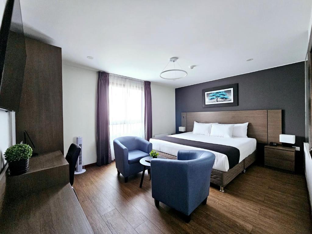 Habitación de hotel con cama, 2 sillas y sofá en Vita Hoteles Arequipa, en Arequipa