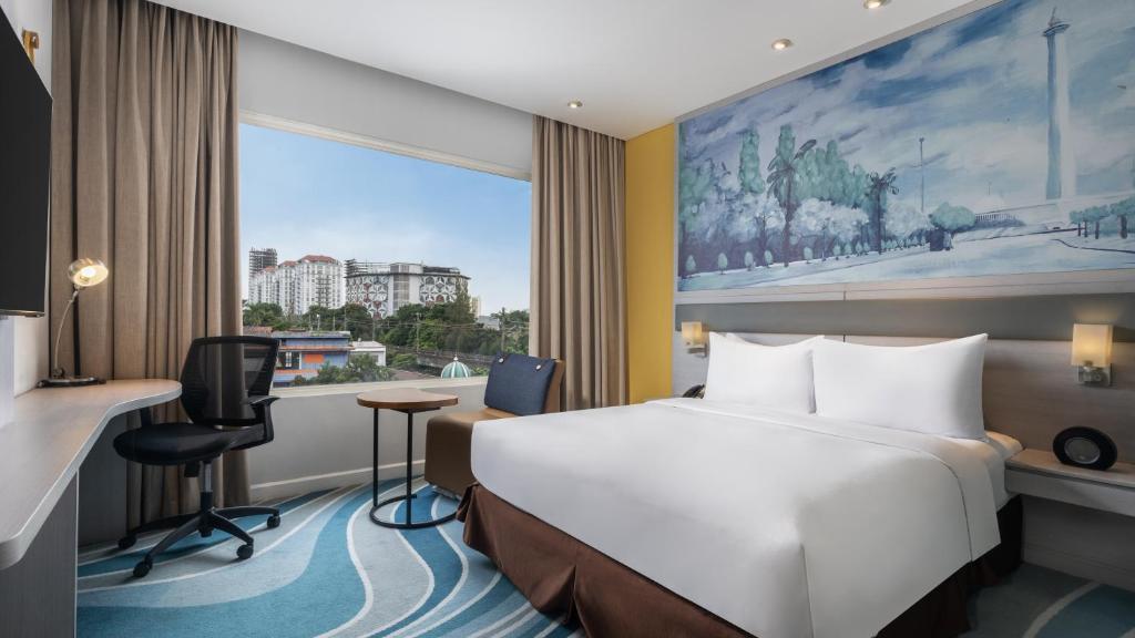 Postel nebo postele na pokoji v ubytování Mercure Jakarta Cikini
