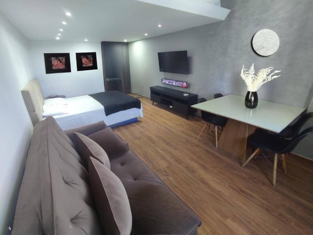 a hotel room with a bed and a couch and a table at Bahia Hotel Sol Vitoria Marina Flats in Salvador