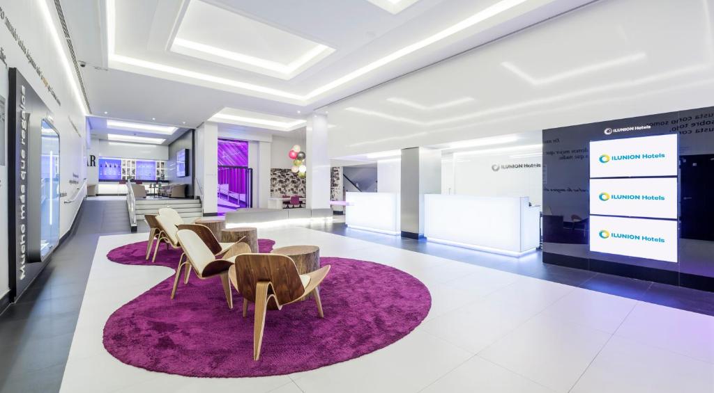 - un hall avec des chaises et un tapis violet dans l'établissement Ilunion Suites Madrid, à Madrid
