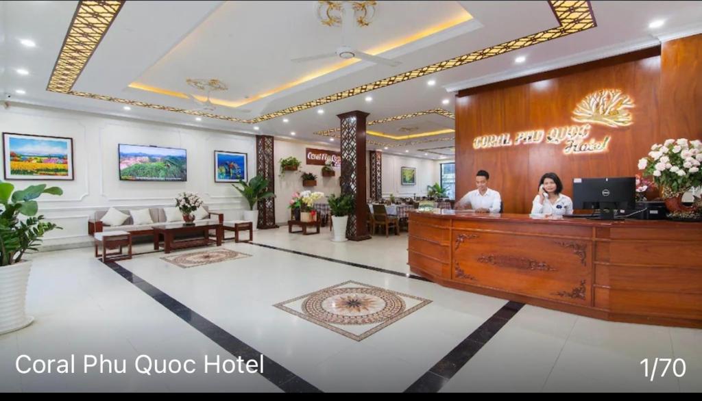 eine Lobby eines Hotels mit zwei Personen, die an einem Tresen stehen in der Unterkunft Coral Hotel Phu Quoc in Phu Quoc