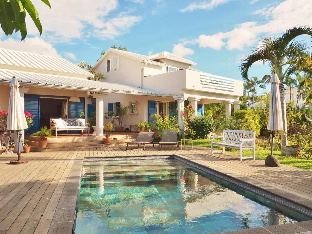 una villa con piscina frente a una casa en Villa Serenite, en F. Sauger