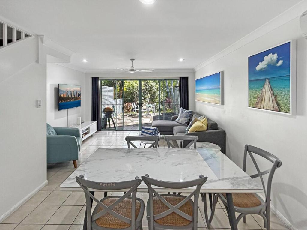 a living room with a table and chairs at Sunset Waters 10 & Free Buggy - Hamilton Island in Hamilton Island