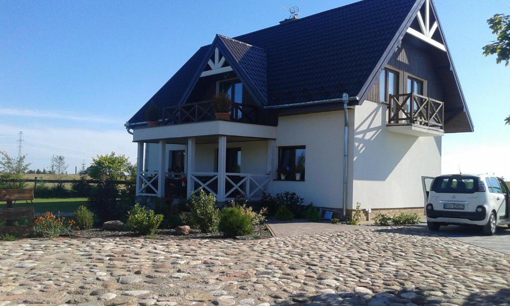 a large white house with a blue roof at Gospodarstwo Rospuda in Bakałarzewo