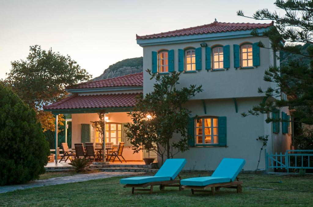 een huis met twee blauwe stoelen ervoor bij Aeolos Villa in Koumeika