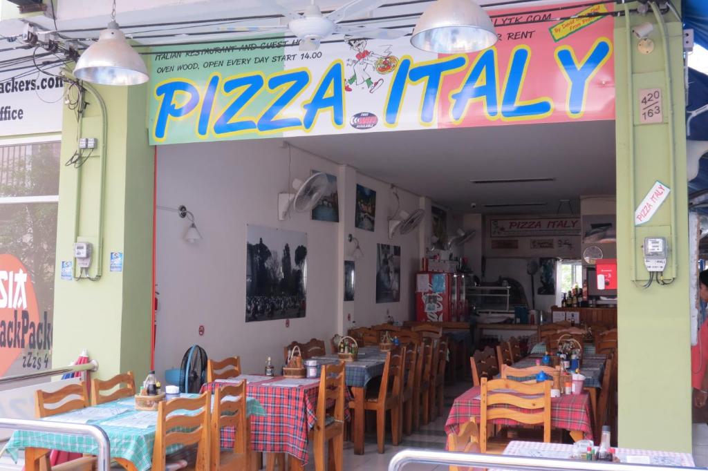un restaurante con mesas y sillas y un cartel que lee pizza italia en Pizza Italy Restaurant and Guesthouse, en Pattaya central