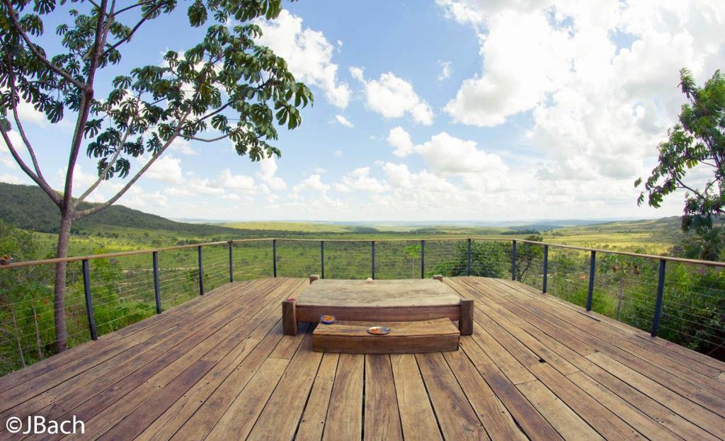 a wooden deck with a bench on top of a hill at Vila Paraíso in Alto Paraíso de Goiás