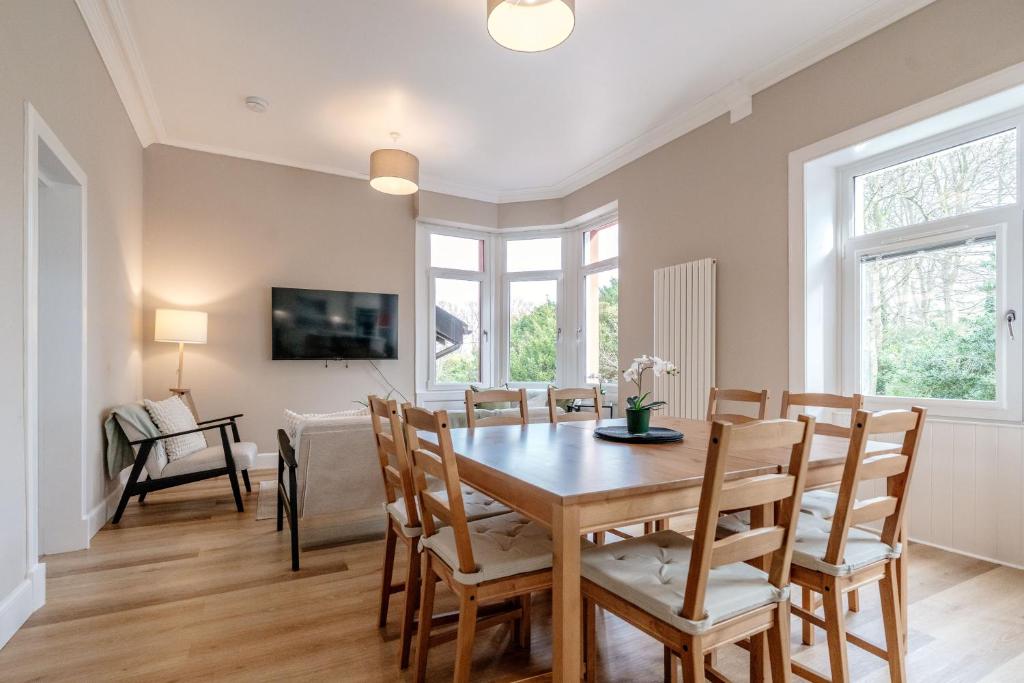a dining room with a wooden table and chairs at Classy private spacious flat in North Berwick