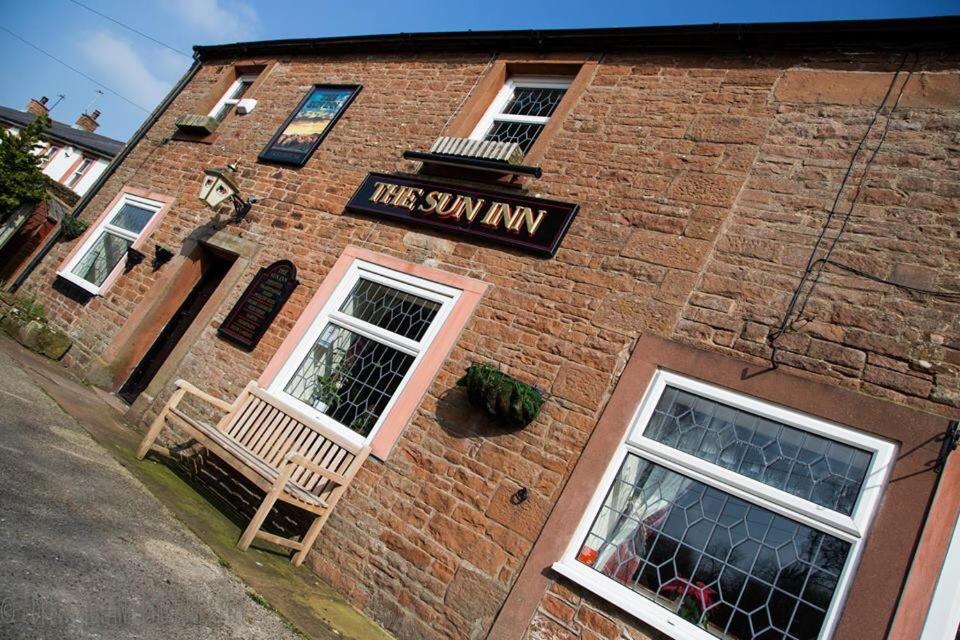 a brick building with a sign that reads the sun inn at The Sun Inn in Penrith