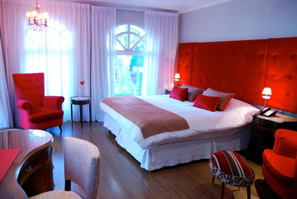 a bedroom with a large bed with a red headboard at Rendez Vous Hotel Buenos Aires in Buenos Aires