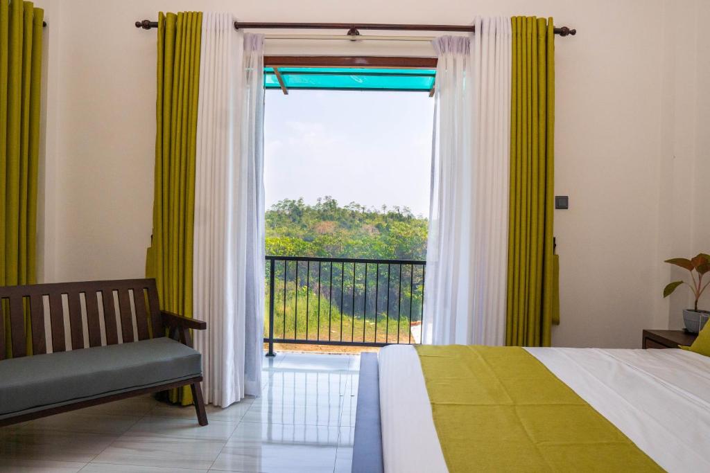 a bedroom with a bed and a window with a balcony at Villa Barbara - Private Pool Villa in Ahungalla in Ahungalla