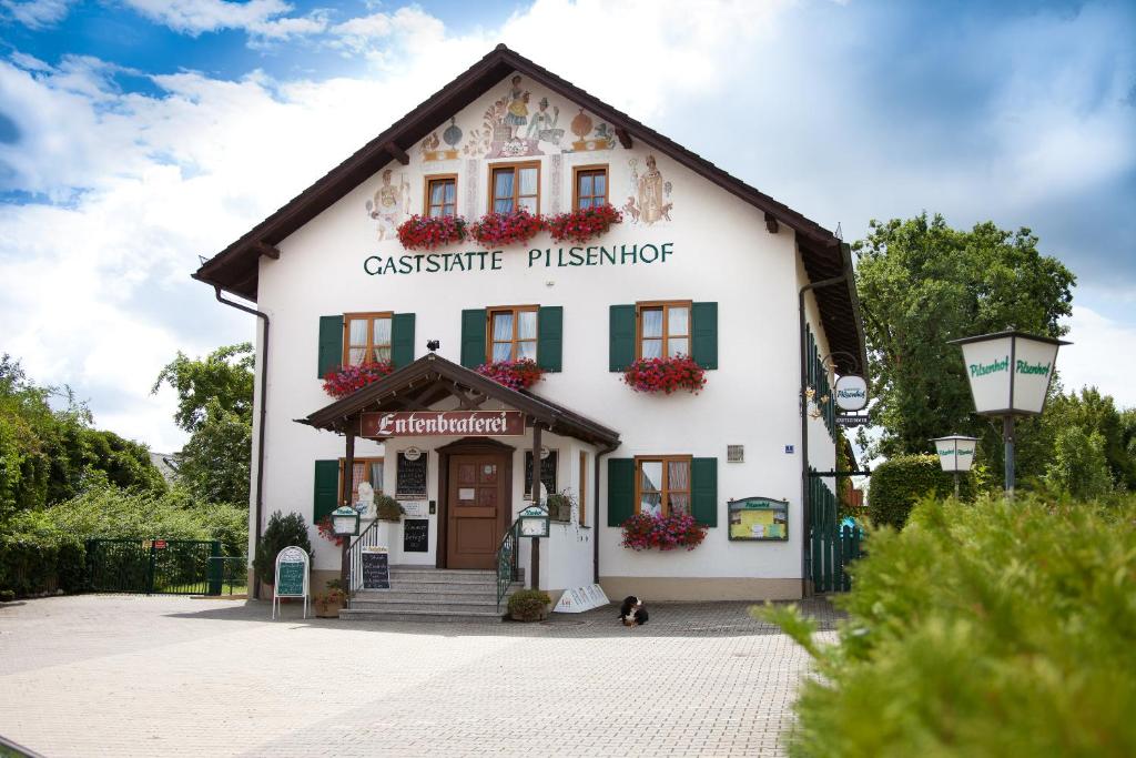 un edificio blanco con un cartel que lee físico cassiusitzeritzer en Landgasthof Pilsenhof Entenbraterei, en Hechendorf am Pilsensee