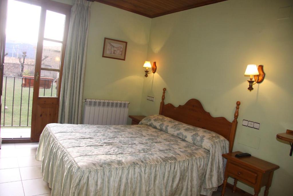 1 dormitorio con cama y ventana grande en Casa Francho, en Laspaúles