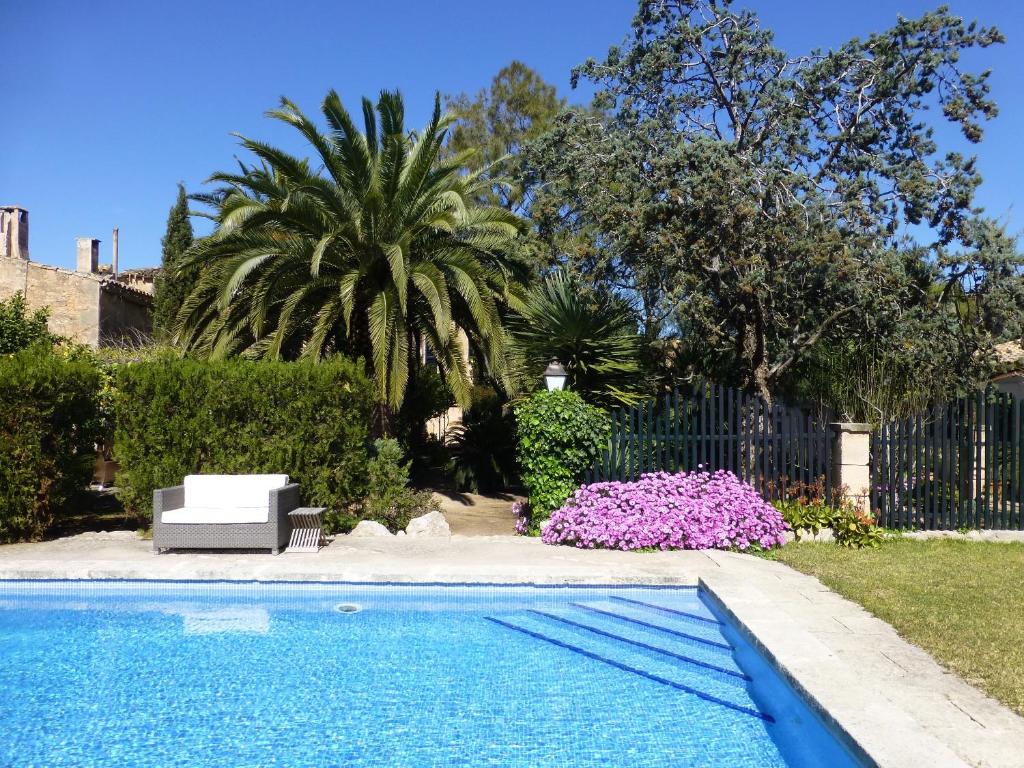 a swimming pool in a yard next to a fence at Finca Raims in Algaida