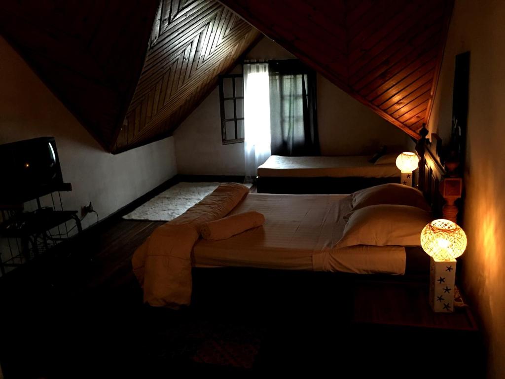 a bedroom with two beds in a room with a window at Le fumoir guest house familiale in Antananarivo