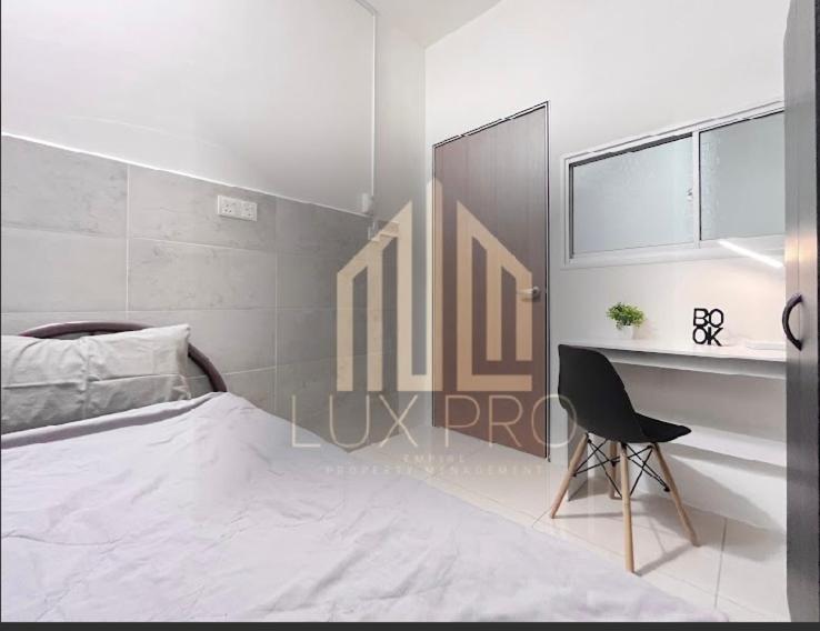 a white bedroom with a bed and a desk at Residensi prima kampung paloh in Ipoh