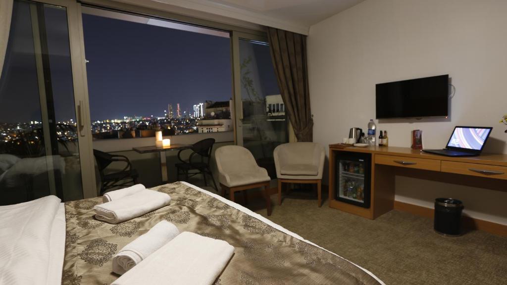una camera d'albergo con un letto, una scrivania e una finestra di PALMIYE hotel SUITES a Istanbul