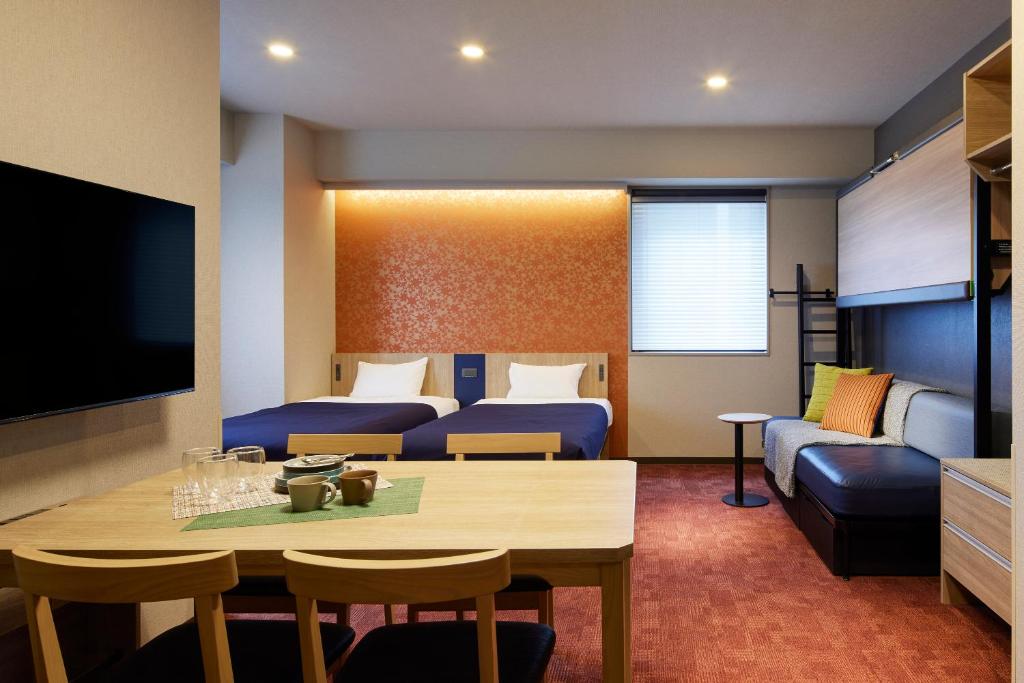 a living room with a table and a room with a couch at Minn Nihonbashi in Tokyo
