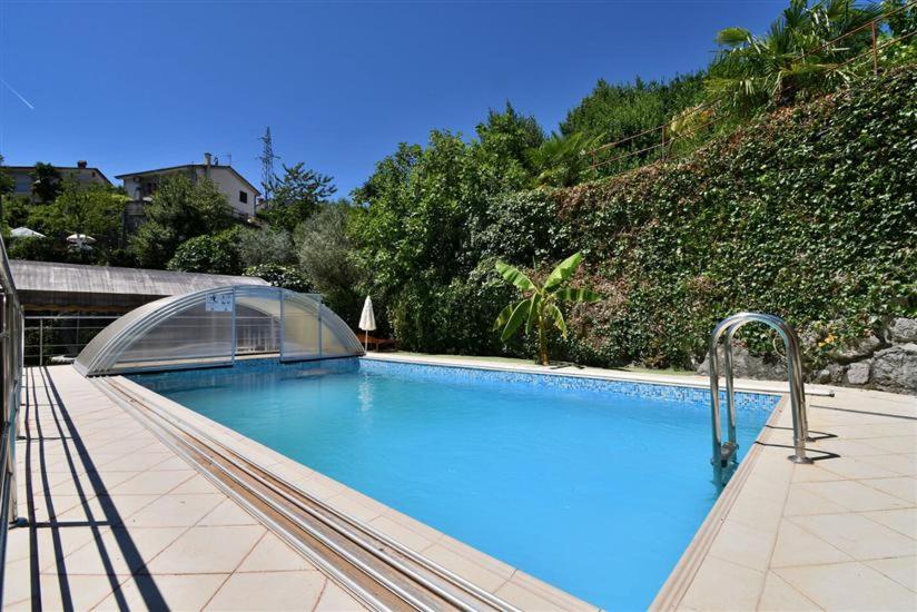 ein großer blauer Pool mit klarer Abdeckung in der Unterkunft Villa Ella in Opatija