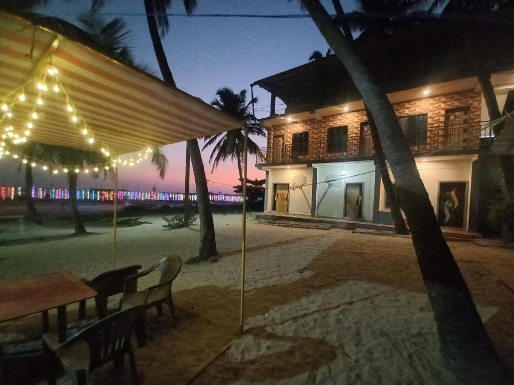 a table and chairs in front of a house at night at Malvan Beach Homestay in Malvan