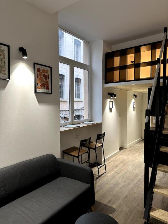 un salon avec un canapé, des chaises et une fenêtre dans l'établissement L'hypercentral - 4 Chapeaux, à Lyon