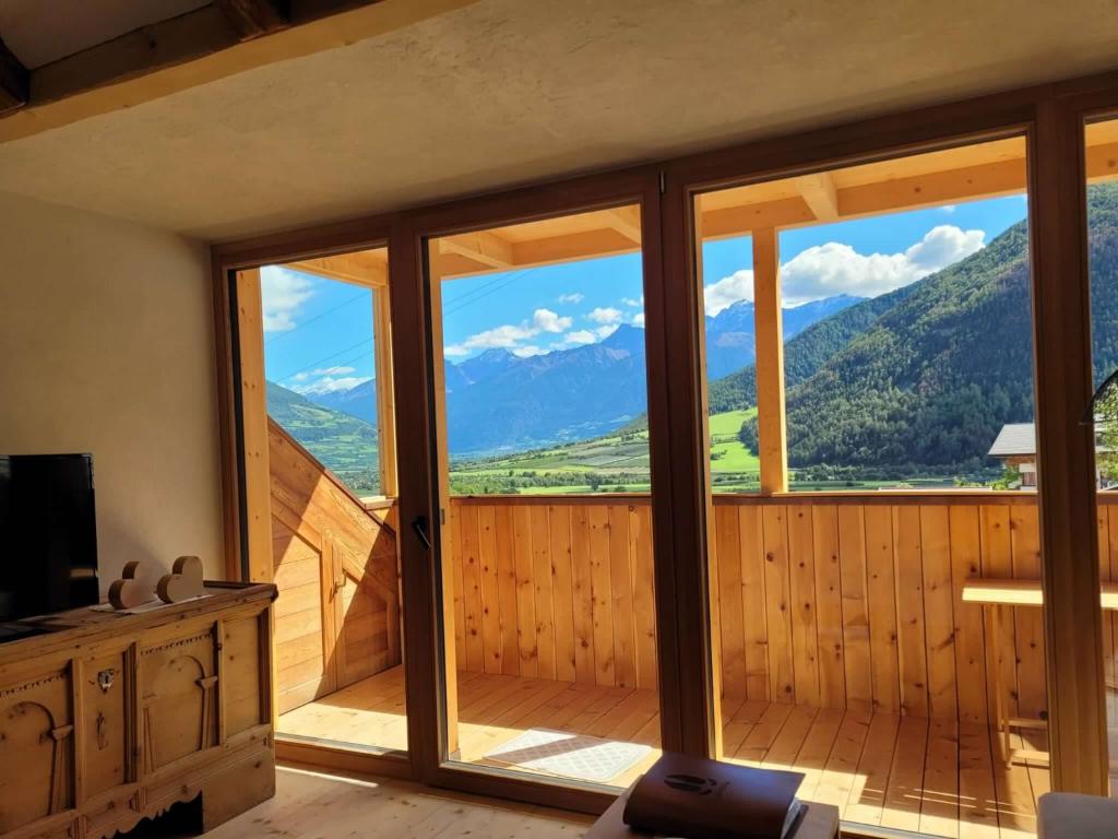 a room with a large window with a view of mountains at Hoamisch in Malles Venosta