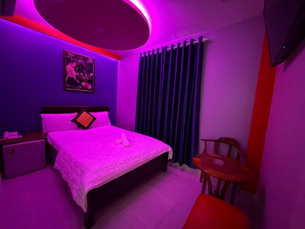a purple bedroom with a bed and a chair at Khách Sạn Lộc Thọ in Ho Chi Minh City