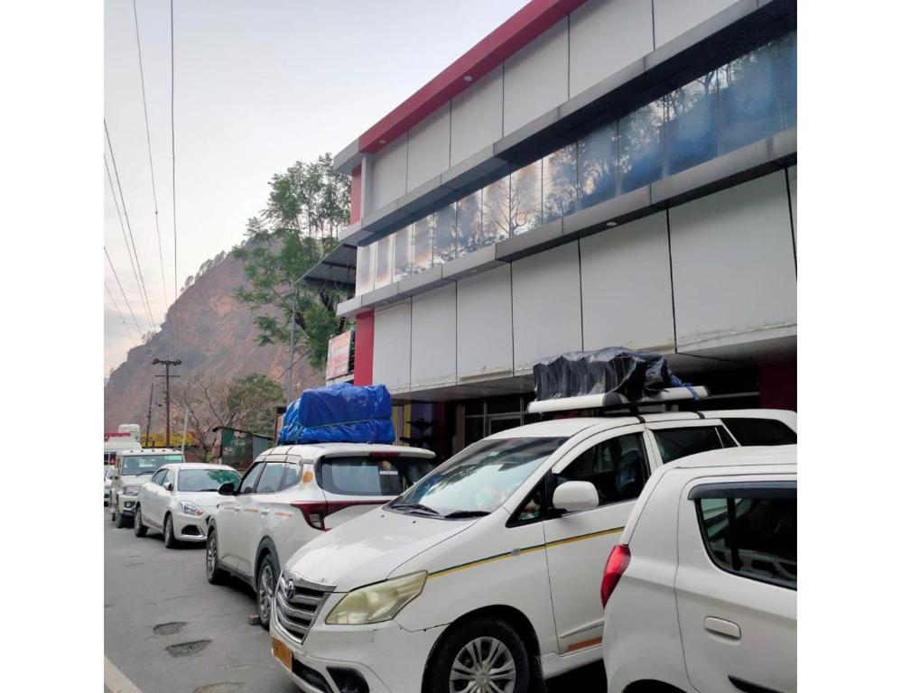 a row of cars parked in front of a building at Jai Badri Vishal Hotel and Restaurant, Pipalkoti in Pīpalkoti