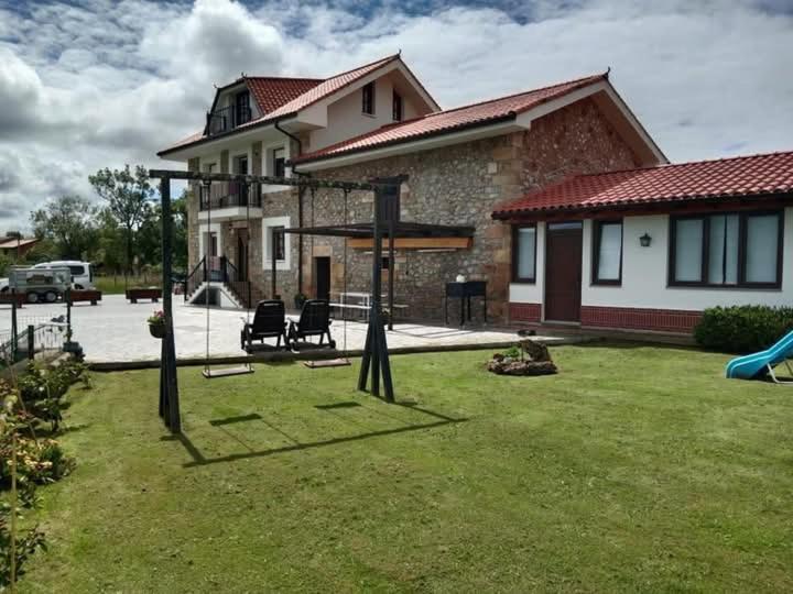 a yard with a playground in front of a house at Vivienda Rural La Mazuga in Cabárceno