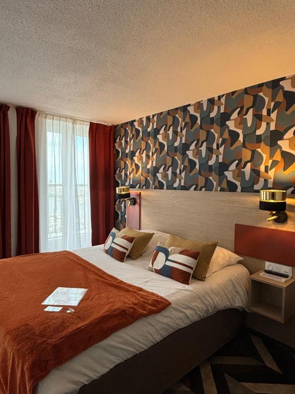 una camera da letto con un letto grande con una grande testiera di Ambassadeur Hotel - Cherbourg Port de Plaisance a Cherbourg en Cotentin