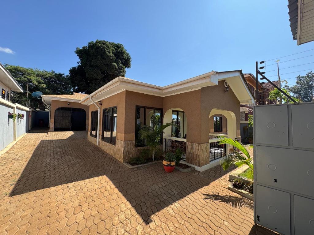 a house with a brick driveway in front of it at Town Retreat Moshi in Moshi