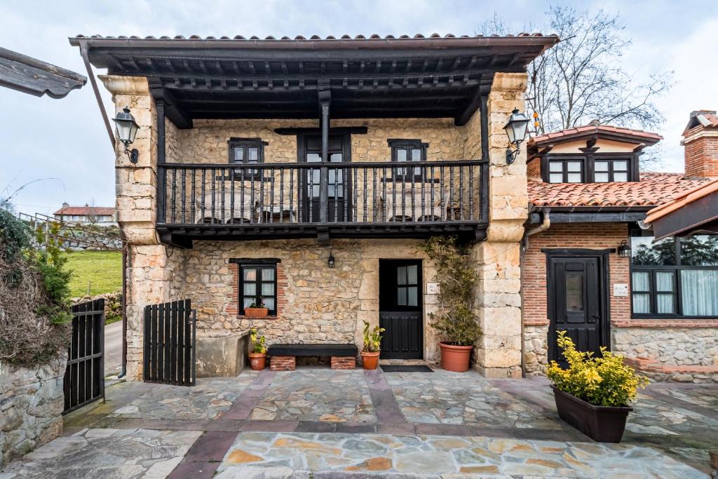 eine Außenansicht eines Steinhauses mit Balkon in der Unterkunft La Casona in San Vicente de la Barquera