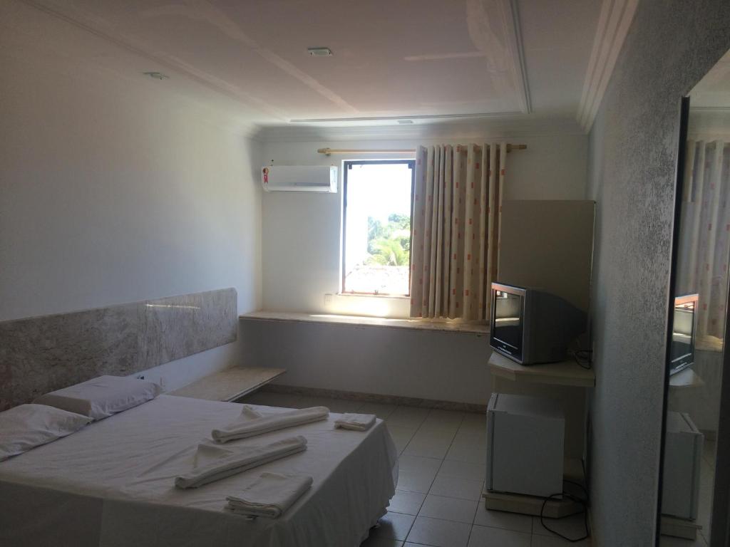 Cette petite chambre comprend un lit et une fenêtre. dans l'établissement Pousada Praia De Guarajuba, à Guarajuba