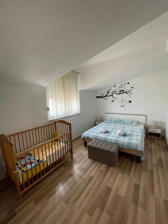 sypialnia z łóżkiem i łóżeczkiem dziecięcym w obiekcie Apartmani Krišto 2 Zadar w mieście Zadar